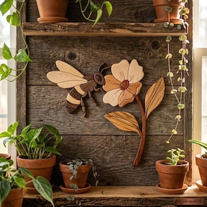 May include: A wooden wall art piece featuring a bee and a flower with five petals and two leaves. The bee is crafted from light and dark wood tones, while the flower displays varied wood grain patterns. The artwork is mounted on a rustic wood panel.