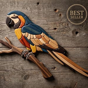 Puede incluir: Una pieza de arte mural de madera con forma de guacamayo posado en una rama. El ave presenta segmentos superpuestos en tonos azul, amarillo, naranja y marrón oscuro. Una insignia circular en la esquina superior derecha contiene el texto BEST SELLER.