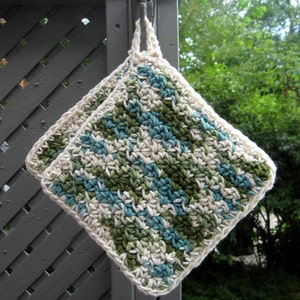 May include: Two crocheted pot holders with a striped pattern in shades of green, blue, and white. The pot holders are hanging on a hook.