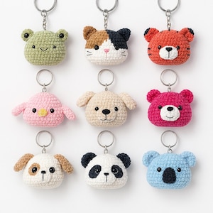 May include: Nine crochet animal keyrings, including a green frog, a calico cat, a red tiger, a pink bird, a beige dog, a fuchsia bear, a white and brown dog, a panda, and a blue koala. Each keyring has a silver metal ring.