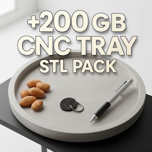 May include: A round, light gray CNC tray with the text "+200 GB CNC TRAY STL PACK". The tray holds almonds, a key fob, and a pen. The tray sits on a black surface.