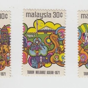 Op de afbeelding: Drie vintage Maleisische postzegels, elk met een unieke kleurrijke illustratie. De postzegels hebben bovenaan de tekst "malaysia 30¢" en onderaan "TAHUN MELAWAT ASEAN-1971". De illustraties tonen verschillende scènes met mensen en gebouwen.