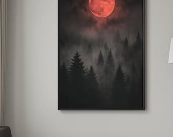 May include: A framed art print depicts a surreal forest scene. A large, red moon dominates the dark sky above silhouetted evergreen trees shrouded in mist. The artwork is framed in a black border and hangs on a white wall.
