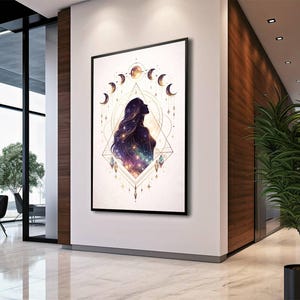 May include: A framed art print featuring a celestial design. The artwork depicts a woman's silhouette with long flowing hair filled with a galaxy of stars. Crescent moons and geometric shapes surround the figure, with a color palette of purple, gold, and white.