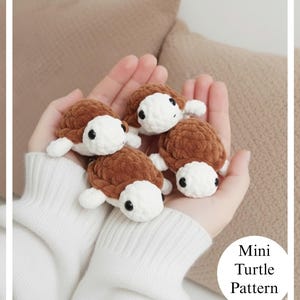Könnte beinhalten: Vier Miniatur-Häkel-Schildkröten in Braun- und Weißtönen werden in gewölbten Händen gehalten. Die Schildkröten haben schwarze Augen und kleine weiße Flossen. Der Text "Mini Turtle Pattern" befindet sich in einem weißen Kreis unten rechts.