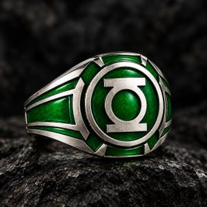 May include: A silver-toned ring featuring a circular face with a raised silver Green Lantern emblem centred on a vibrant green background. The band and the outer edge of the circular face are crafted from polished silver metal with green accents.