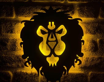 Puede incluir: Silueta negra de cabeza de león de metal con interior amarillo brillante, montada en una pared de ladrillo. La melena y los rasgos faciales del león son detallados, y la luz crea un efecto dramático.