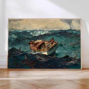 Puede incluir: Una impresión enmarcada de una pintura que representa un pequeño bote en aguas oceánicas turbulentas y azul oscuro. Los tiburones rodean el bote y una persona está sentada dentro. El cielo está nublado con un tono claro y amarillento.