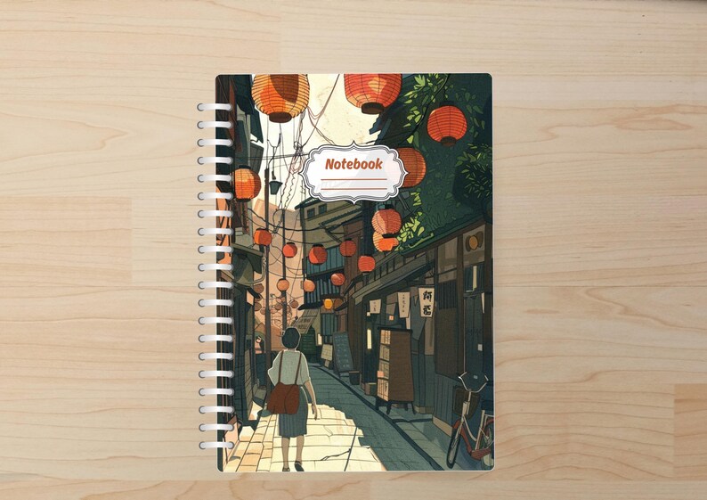 May include: Spiral-bound notebook featuring an illustrated Japanese street scene. The cover art depicts a person walking down a lantern-lit alleyway. The word "Notebook" is displayed in a decorative label. The color palette includes warm oranges, greens, and browns.