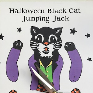 May include: A printable Halloween craft for kids featuring a black cat jumping jack. The craft includes a black cat with a purple jacket, a green vest, and orange and black checkered pants. The image also includes a pair of scissors.