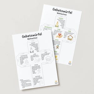 May include: Two white paper sheets with German text and illustrations. The top sheet reads "Gebetswürfel Weihnachten" and features a cross-shaped design with illustrations of a candle, heart, and nativity scene. The bottom sheet has the same design.