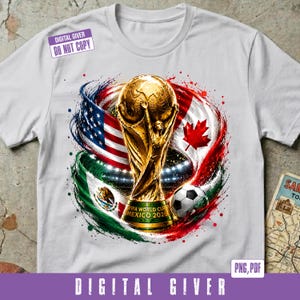 May include: A white t-shirt featuring a graphic of the FIFA World Cup trophy centered above the text MEXICO 2026. The design includes the flags of the United States, Canada, and Mexico swirling around the trophy, alongside a soccer ball.