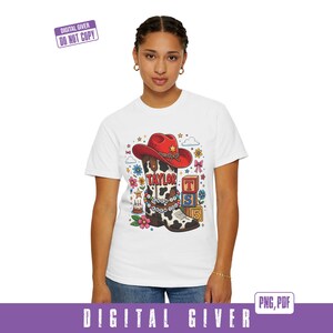 May include: A white short-sleeved t-shirt featuring a graphic of a cow-print cowboy boot with a red hat, a beaded bracelet with the text I KNEW IT I KNEW YOU, the name TAYLOR, colorful flowers, a small birthday cake, and stacked alphabet blocks.
