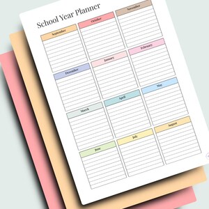 Puede incluir: Un planificador del año escolar con un fondo blanco y secciones mensuales coloridas. El planificador incluye los meses del año escolar, de septiembre a agosto. El planificador está apilado sobre papel rosa y beige.