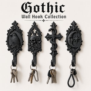 May include: Four black wall hooks from the Gothic Wall Hook Collection, featuring designs of a raven, a skull with roses, a snake-wrapped cross, and a crescent moon with a star. Each hook holds a metal ring with various keys attached.