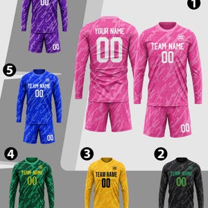 May include: A collection of six long-sleeve athletic jersey and shorts sets in purple, pink, blue, green, yellow, and black. Each set features a camouflage pattern, the text TEAM NAME, the number 00, and a circular logo placeholder.