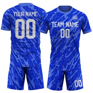 May include: A blue soccer uniform set with a patterned design. The jersey and shorts feature the number "00" in white. The jersey has the text "YOUR NAME" on the back and "TEAM NAME" on the front, with space for a logo.