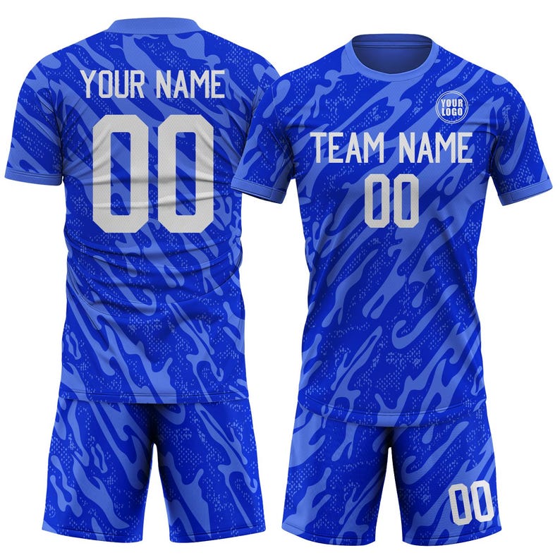 May include: A blue soccer uniform set with a patterned design. The jersey and shorts feature the number "00" in white. The jersey has the text "YOUR NAME" on the back and "TEAM NAME" on the front, with space for a logo.