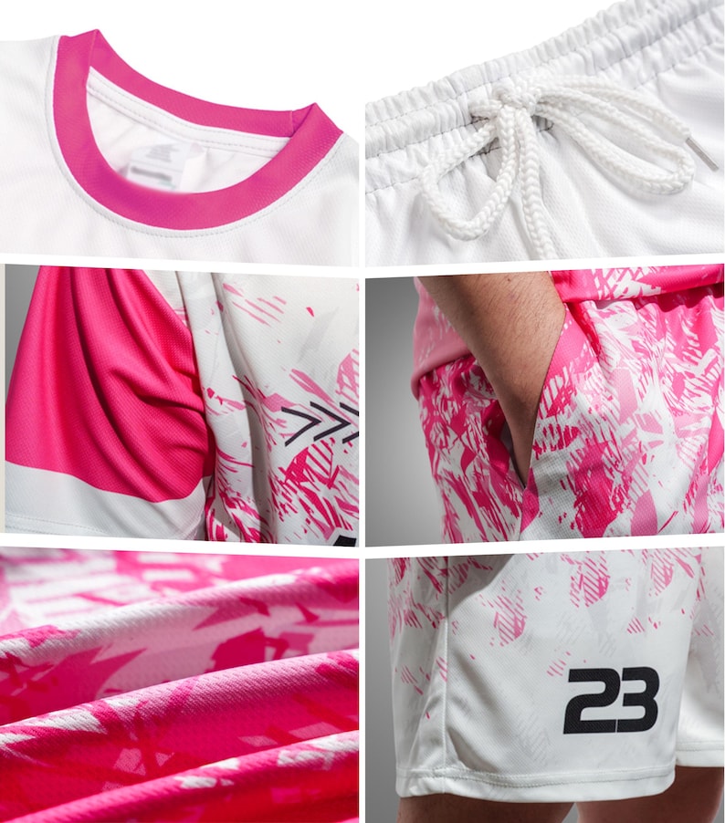 May include: White athletic shirt and shorts set with pink accents. The shirt has a pink collar and sleeve details. The shorts feature a pink and white abstract design and the number 23. The shorts have a drawstring waist.