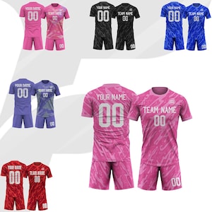 May include: A collection of soccer uniforms in various colors, including pink, black, blue, purple, and red. Each uniform set includes a jersey and shorts, with the text "YOUR NAME", "TEAM NAME", and the number "00" printed on them. The jerseys have a patterned design.