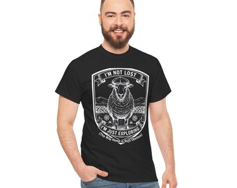 May include: Black t-shirt with a white graphic of a sheep inside a shield. The text reads "I'M NOT LOST I'M JUST EXPLORING (The Way Home Is Really Obvious)". The shirt is made of a soft material.
