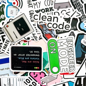 Op de afbeelding: Een verzameling witte stickers met diverse ontwerpen en tekst. Sommige stickers tonen computergerelateerde thema's, waaronder een retro computer met een lachend gezicht, de woorden "clean code" en "engineer mode". Andere stickers hebben zinnen als "I hate" en binaire code.