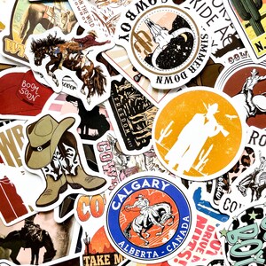 May include: A collection of cowboy-themed stickers with various designs. The stickers feature images of horses, cowboy boots, hats, and text like "Cowboy," "Freedom West," and "Calgary Alberta Canada." The color palette includes brown, orange, and blue.