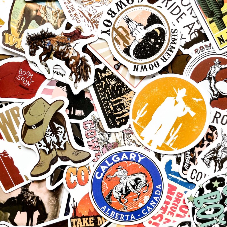May include: A collection of cowboy-themed stickers with various designs. The stickers feature images of horses, cowboy boots, hats, and text like "Cowboy," "Freedom West," and "Calgary Alberta Canada." The color palette includes brown, orange, and blue.