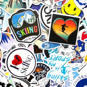 Peut inclure: Un assortiment d'autocollants colorés avec divers motifs. Certains autocollants présentent des thèmes de ski, notamment des paysages de montagne, des skieurs et le texte "SKIING". D'autres autocollants ont un cœur avec un skieur et le texte "I LOVE SKIING".