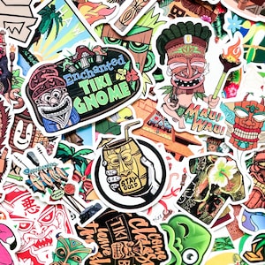 Può includere: Una collezione di adesivi colorati a tema Tiki. I disegni includono maschere Tiki, uno gnomo, un cocktail e grafiche di camicie tropicali. Gli adesivi presentano colori vivaci e vari elementi testuali, creando un'estetica divertente.