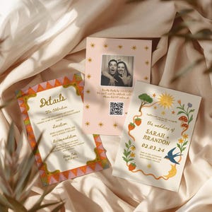 May include: Wedding stationery set on cream fabric. The set includes invitations and details cards. The invitations feature a photo, floral and celestial designs, and the names Sarah and Brandon.