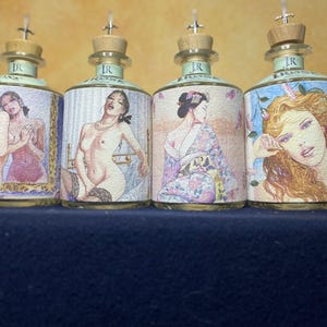 Puede incluir: Cuatro botellas de vidrio con tapones de madera y vertedores, cada una con una ilustración única en la etiqueta. Las etiquetas muestran varias figuras, incluyendo una persona frente a un espejo, una persona en lencería, en kimono y un retrato.