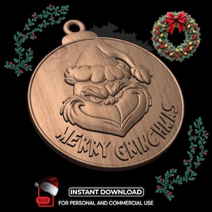 Könnte beinhalten: Weihnachtsschmuck aus Holz mit dem Gesicht des Grinch, mit den Worten "MERRY GRINCHMAS" in das Holz geschnitzt. Ein kleiner Kranz mit roter Schleife und Stechpalmenzweigen ist ebenfalls sichtbar. Der Anhänger hat eine Schlaufe zum Aufhängen.