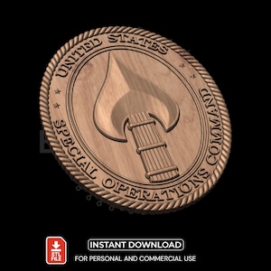 Puede incluir: Medallón de madera con el texto "UNITED STATES SPECIAL OPERATIONS COMMAND" que rodea un emblema central. El emblema presenta una llama sobre un haz de varillas. El medallón tiene un borde en forma de cuerda y detalles de estrellas.