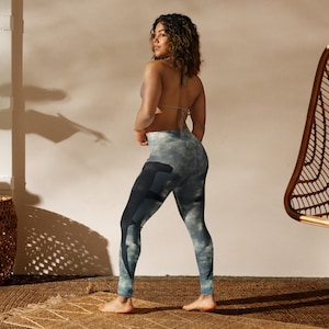 Op de afbeelding: Hoge taille leggings met een wolkenhemelontwerp in grijstinten en blauw. Deze leggings zijn gemaakt van een rekbaar materiaal, geschikt voor yoga of casual wear. Het ontwerp bedekt de volledige lengte van de legging.