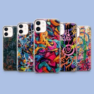 May include: A collection of five phone cases with vibrant graffiti art designs. The cases feature a variety of colors, including blue, orange, pink, and green, with abstract and street art-inspired patterns. Each case has a clear border.