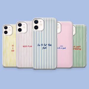 Pode incluir: Uma coleção de cinco capas de telefone com padrões de listras verticais em amarelo, rosa, azul e verde. Cada capa apresenta uma citação inspiradora diferente em estilo manuscrito, como "Life is good" e "Do it for the plot".