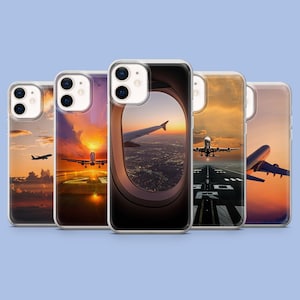 Può includere: Una collezione di custodie trasparenti per telefoni con design a tema aereo. Ogni custodia mostra una diversa scena del tramonto con un aereo, comprese le viste dalla finestra, in decollo e in volo. Le custodie hanno un bordo trasparente.