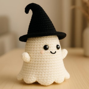 Peut inclure: Un fantôme crocheté portant un chapeau de sorcière noir. Le fantôme est blanc cassé avec un visage souriant, des joues roses et de petits bras. Le chapeau a un sommet incurvé et un large bord. Article fait main.
