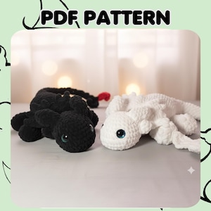 Puede incluir: Dos juguetes de dragón de ganchillo, uno negro y otro blanco, con grandes ojos azules. El dragón negro tiene una aleta roja. La imagen incluye el texto "PDF PATTERN" en la parte superior, lo que indica un patrón para hacer estos juguetes.