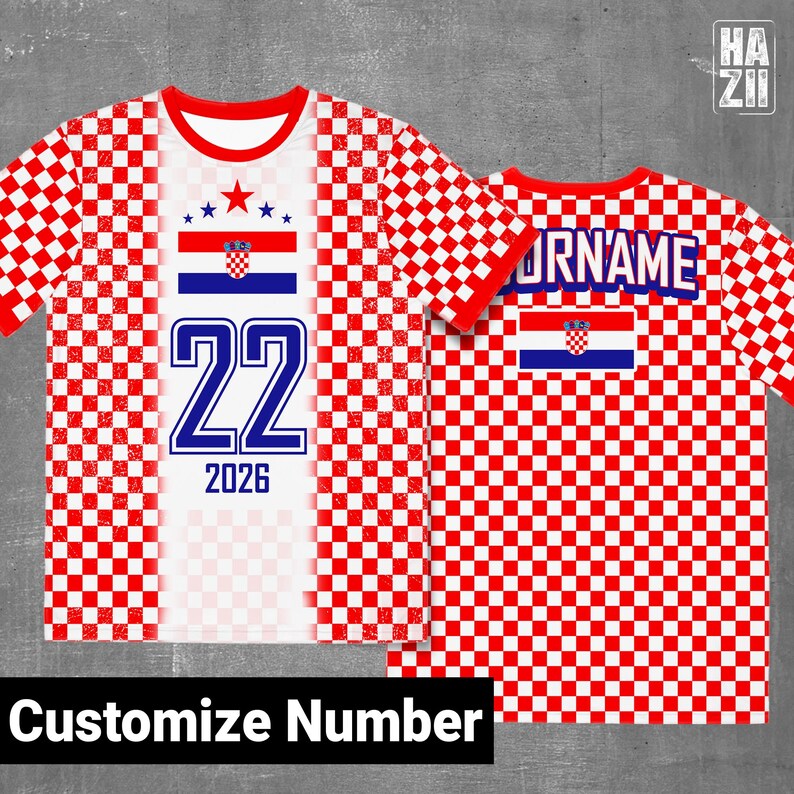 May include: A short-sleeve t-shirt featuring a red and white checkered pattern. The front displays the Croatian flag, the number 22, and the year 2026. The back shows the text YOURNAME above the Croatian flag. The design includes a red crew neck.