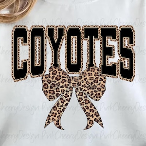 Może przedstawiać: Biała bluza z napisem "COYOTES" w czarnych literach blokowych z nadrukiem w cętki. Łuk w cętki jest wyśrodkowany pod słowem. Bluza to swobodny styl.