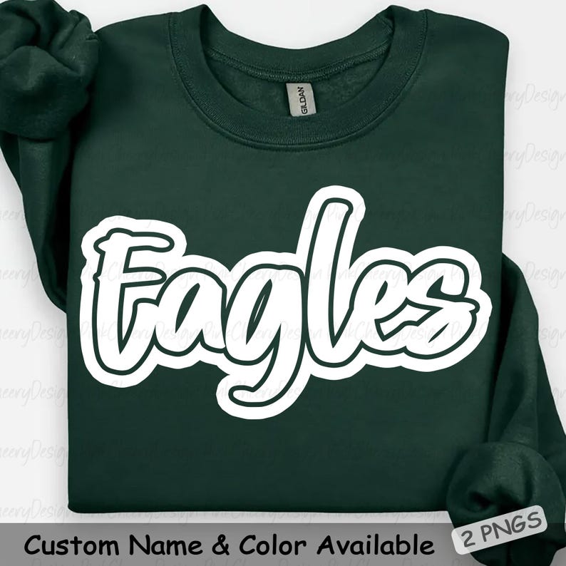 May include: A dark green sweatshirt with the word "Eagles" in a white, stylized font. The text is outlined in black. The sweatshirt has a crew neck and long sleeves. The text "Custom Name & Color Available" is at the bottom.