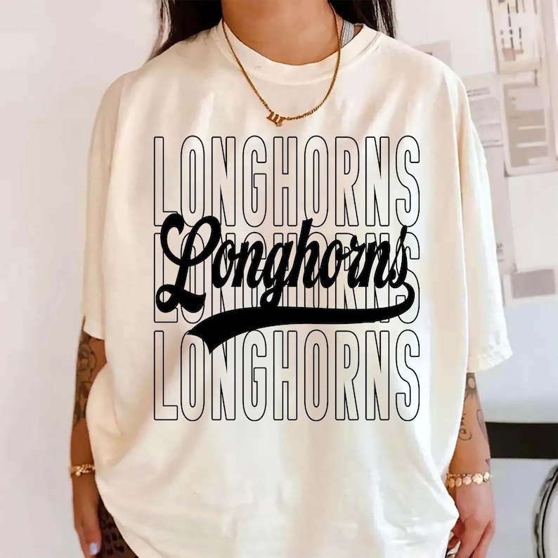 Puede incluir: Camiseta color crema con la palabra "LONGHORNS" en un dise&ntilde;o apilado. La palabra "Longhorns" se repite tres veces en una fuente negra en negrita, con una versi&oacute;n de gui&oacute;n estilizada en el centro. Una l&iacute;nea negra curva subraya el gui&oacute;n.
