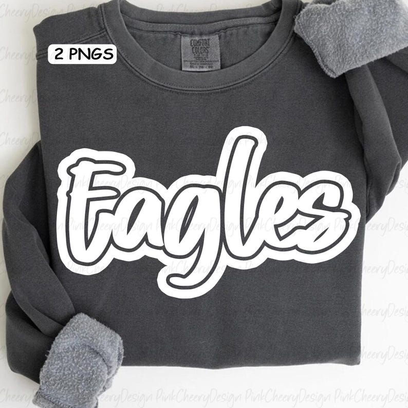 May include: A dark gray sweatshirt with the word "Eagles" in large, white, outlined letters across the front. The sweatshirt has long sleeves and a crew neck. The text "2 PNGS" is in the upper left corner.