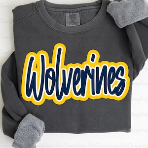 Op de afbeelding: Donkergrijze sweatshirt met het woord "Wolverines" in geel en marineblauw. De sweatshirt heeft een ronde hals en een zachte, met fleece gevoerde binnenkant. De mouwen zijn afgewerkt met een grijs, zacht materiaal.