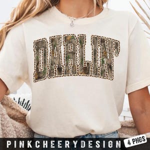 May include: Cream-colored t-shirt featuring the word "DARLIN" in a bold, block letter design. The letters are filled with a camouflage pattern and outlined with a leopard print. The text "PINKCHEERYDESIGN 4 PNGS" is at the bottom.