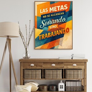 Peut inclure: Affiche encadrée avec le texte "LAS METAS NO SE ALCANZAN Soñando SINO TRABAJANDO" en orange, bleu et jaune. L'affiche est au-dessus d'une console en bois avec trois tiroirs et trois paniers en osier. Un lampadaire et des objets décoratifs sont également présents.