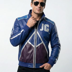 May include: A blue leather jacket with silver accents and a purple lower panel. The jacket features the letters "JC" in silver on the chest. The jacket has a zip-up front and a ribbed collar and cuffs.