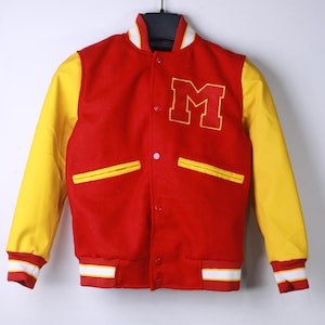 May include: A red and yellow varsity jacket with the letter "M" on the chest. The jacket has yellow sleeves, white and yellow striped cuffs and a white collar. The jacket is hanging on a black hanger.